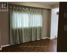 A room with a curtain and a wooden floor.