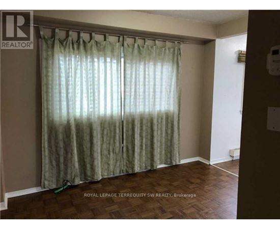 A room with a curtain and a wooden floor.