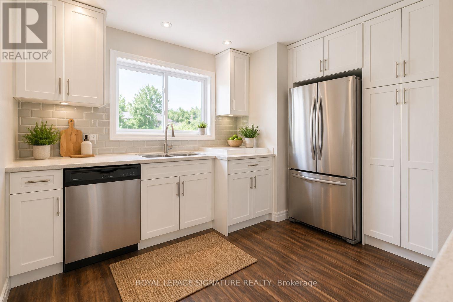 A modern kitchen with white cabinets and a stainless steel refrigerator.