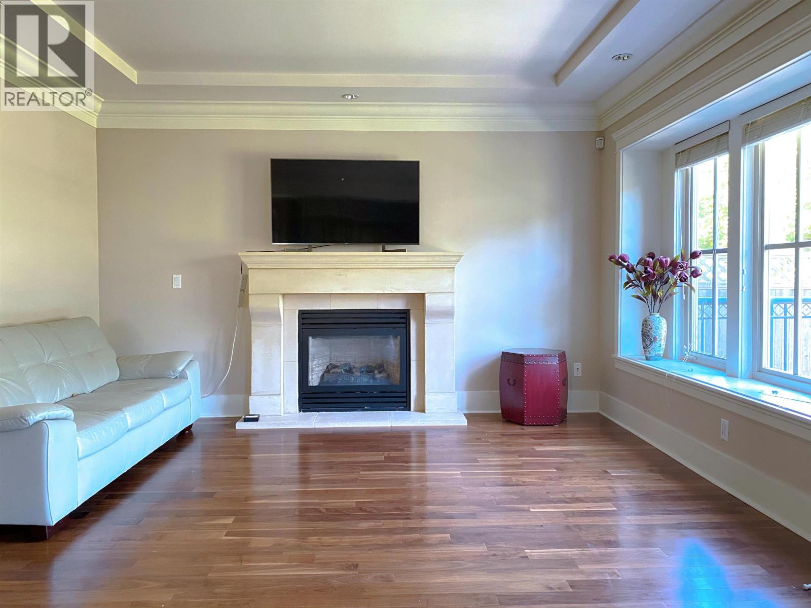 A living room with a fireplace and a television on the wall.