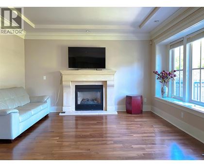 A living room with a fireplace and a television on the wall.