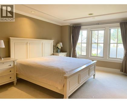 A bedroom with a bed, nightstand, and window.