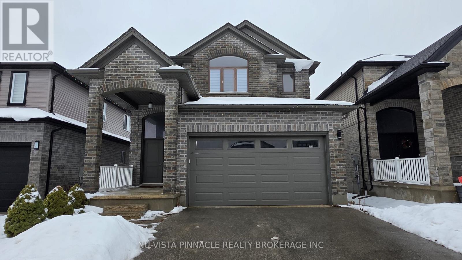 A house with a snow-covered front yard and a garage door.
