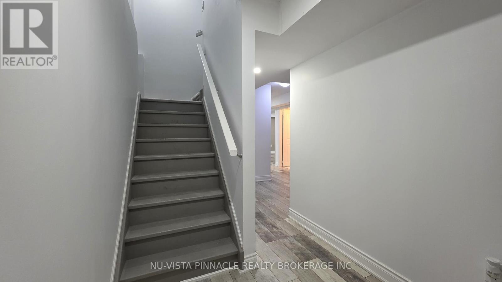 A staircase in a house with a logo on the wall.