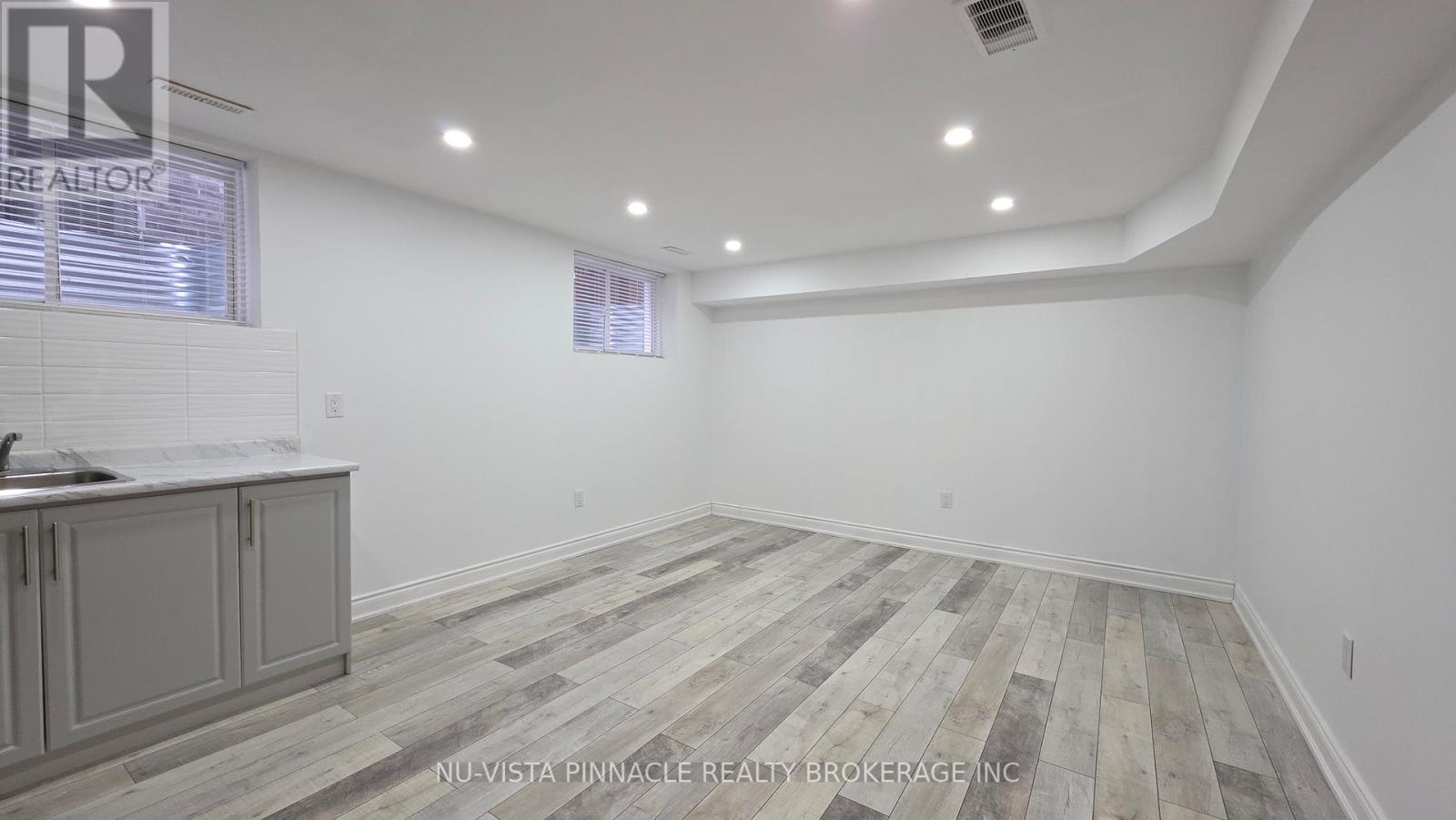 A room with wooden flooring and white walls.
