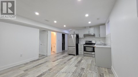 A kitchen with white cabinets and a stainless steel refrigerator.