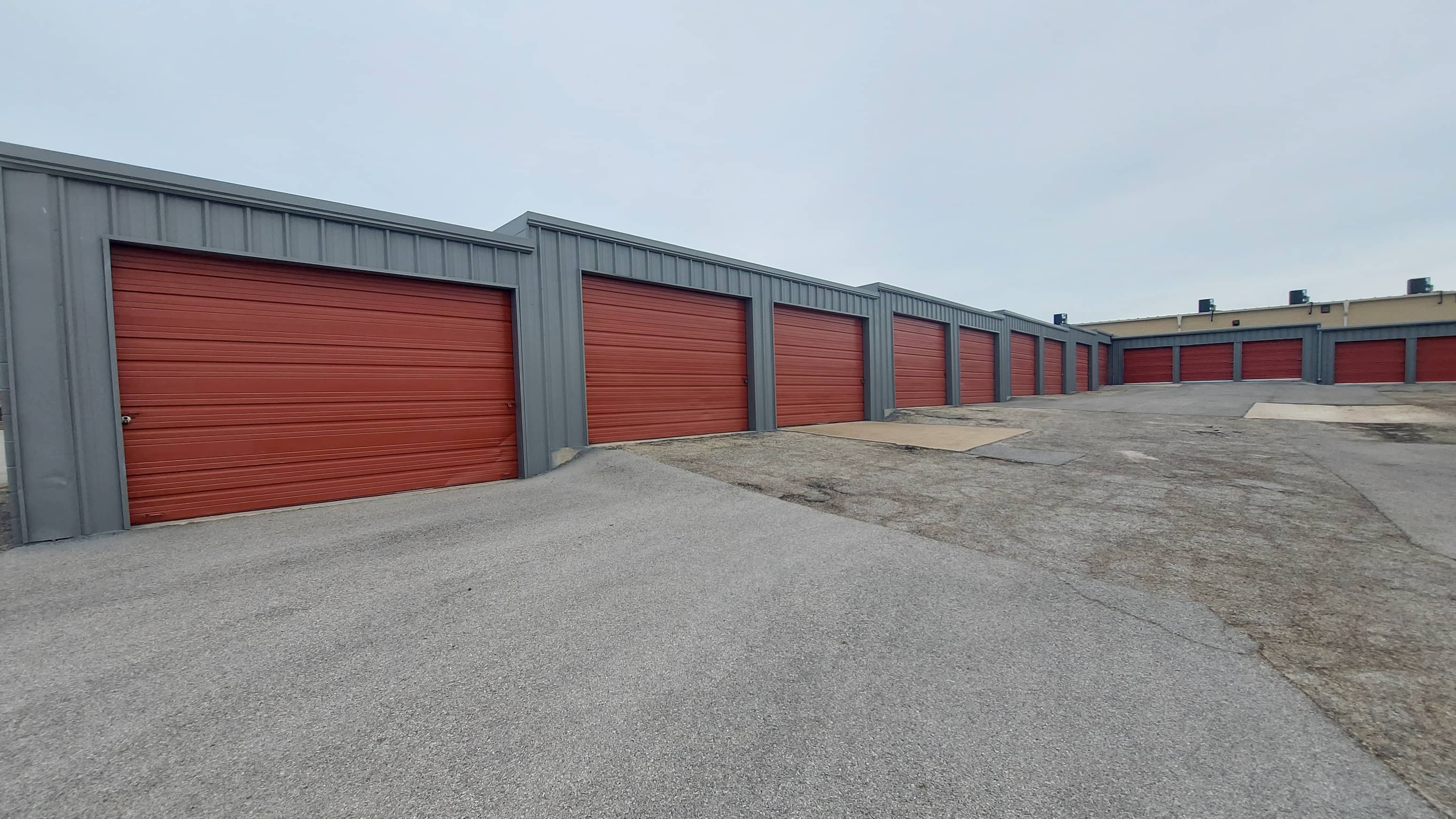 A long row of red garage doors are closed.