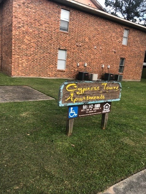 A sign in front of a building that says "Express Tow Apartments".
