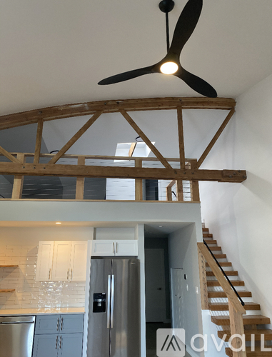 A spacious room with a staircase and a fireplace.