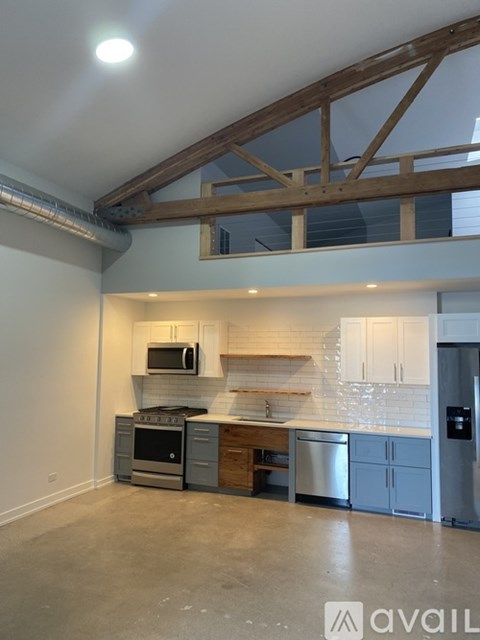 A modern kitchen with a white countertop and stainless steel appliances.