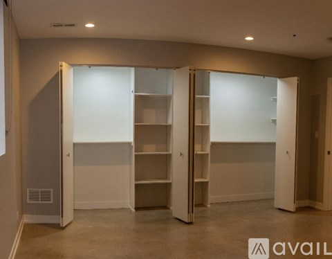 Three white closet doors are open in a room.