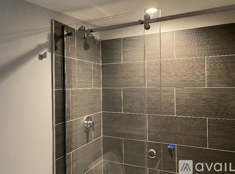 A bathroom with a shower and tiled walls.
