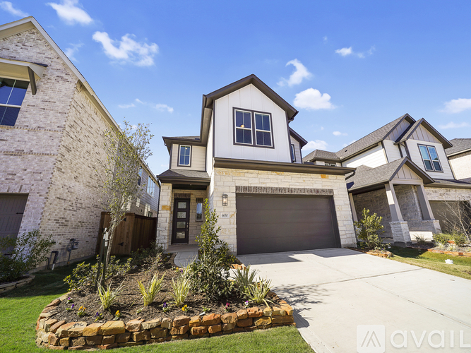 A house with a white and brown exterior and a garage door is for sale.