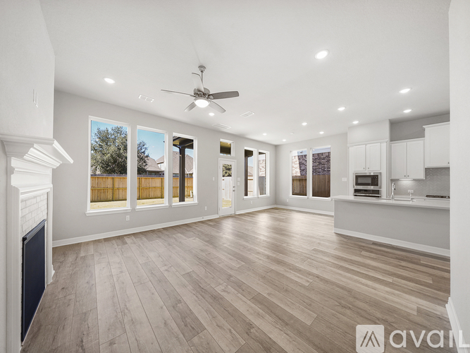 A spacious living room with a fireplace and hardwood flooring.