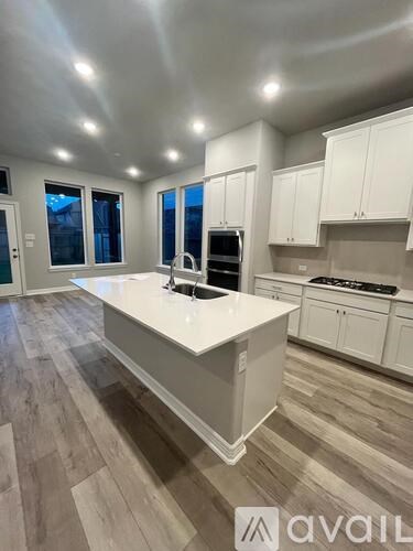 A kitchen with white cabinets and a large island.