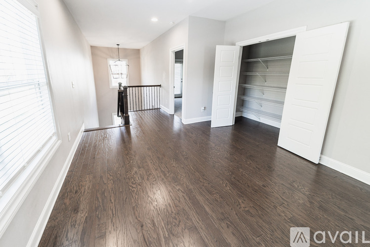 A spacious room with wood flooring and a large open closet.