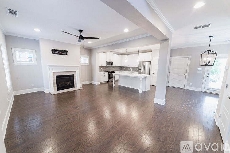 A spacious living room with wood flooring and a fireplace.