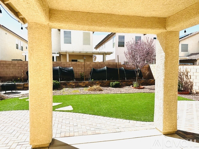 A patio area with a stone walkway and a green lawn.