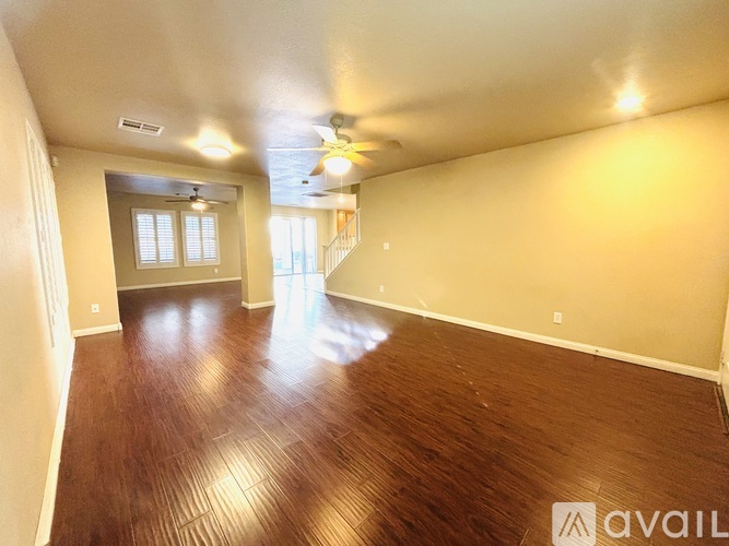 A room with wooden flooring and a ceiling fan.
