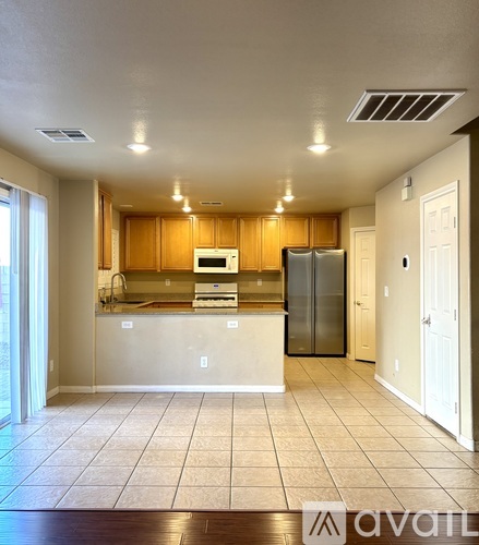 A kitchen with wooden cabinets and a refrigerator.