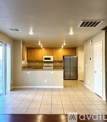 A kitchen with wooden cabinets and a refrigerator.