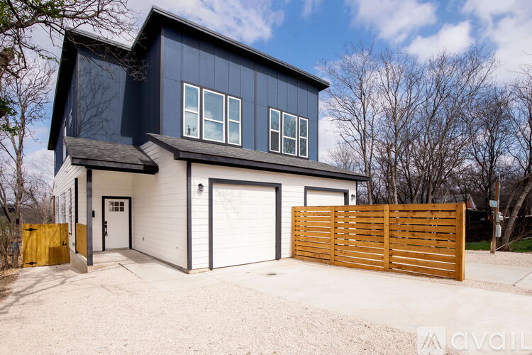 A modern house with a garage and a wooden fence.