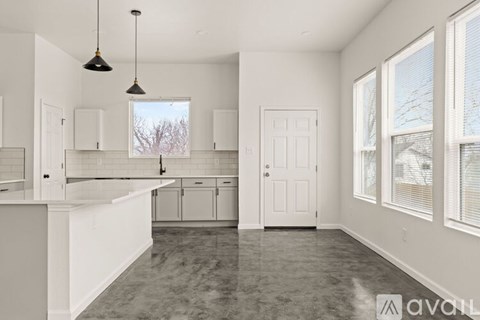 A kitchen with white cabinets and a large island.