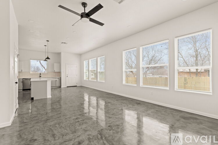 A spacious room with a marble floor and a ceiling fan.
