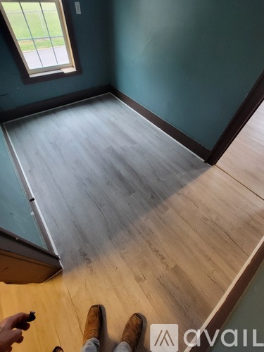 A room with wooden flooring and a window.