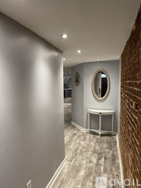 A bathroom with a round mirror and a white sink.