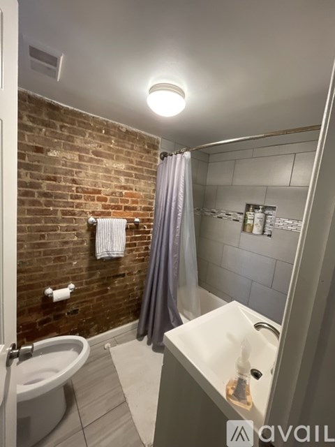 A bathroom with a brick wall and a white sink.