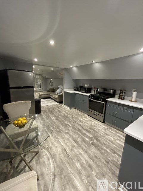 A modern kitchen with a glass table and a bowl of lemons on it.