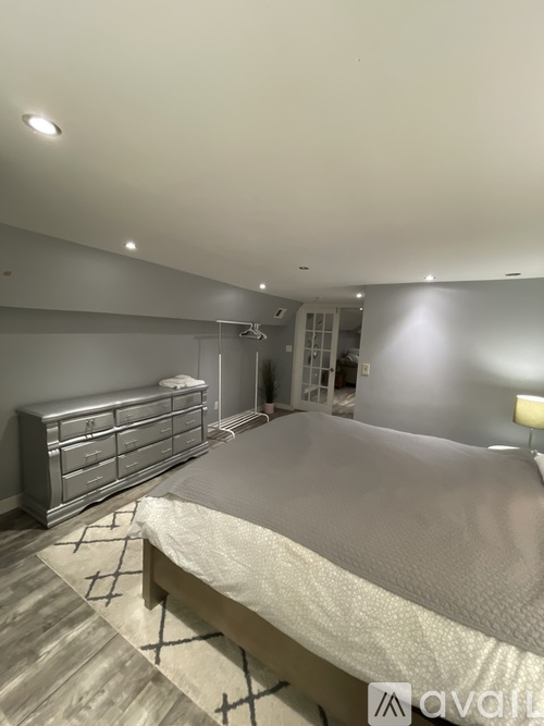 A bedroom with a large bed and a dresser.