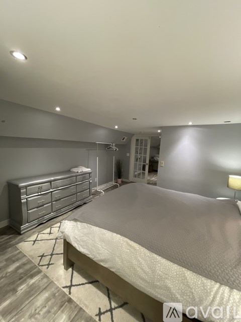 A bedroom with a large bed and a dresser.