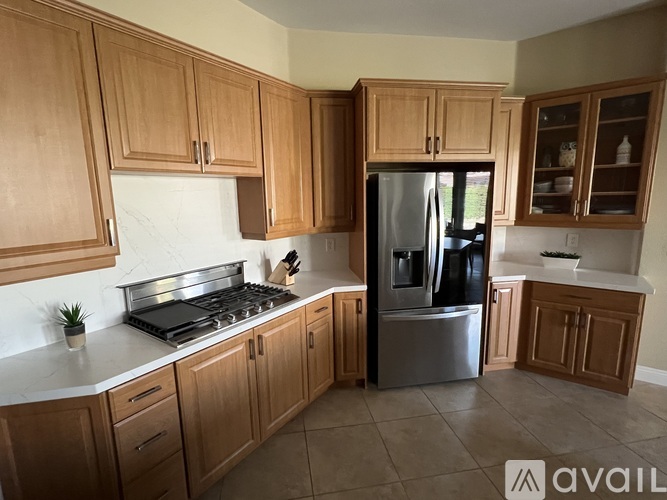 A kitchen with wooden cabinets and a stainless steel refrigerator.