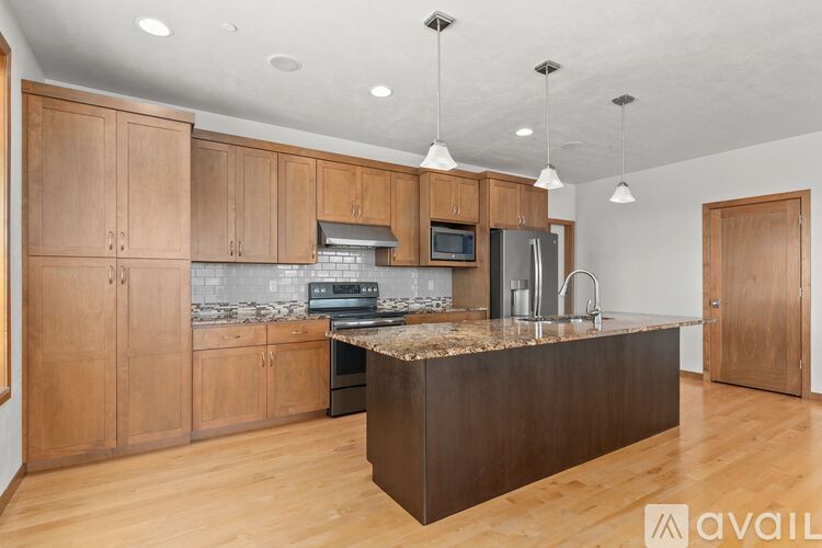 A kitchen with wooden cabinets and a marble countertop.