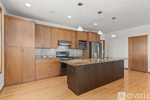 A kitchen with wooden cabinets and a marble countertop.