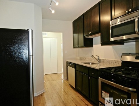 A kitchen with black appliances and wooden cabinets.