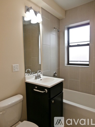 A bathroom with a white sink and black cabinet.
