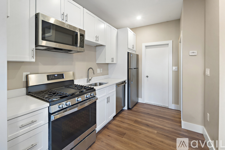 A kitchen with white cabinets and a black stove top oven.