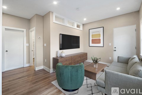 A living room with a green chair and a grey couch.