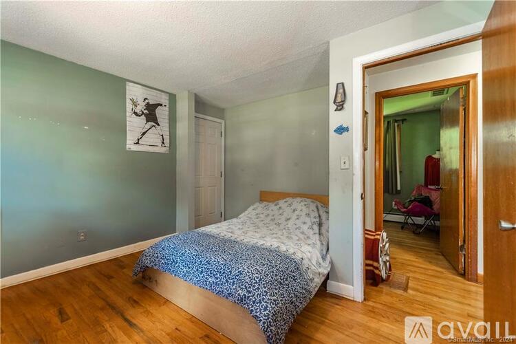 A bedroom with a bed and a painting on the wall.