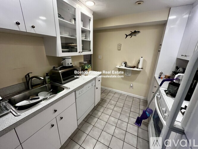 A kitchen with white cabinets and a sink.