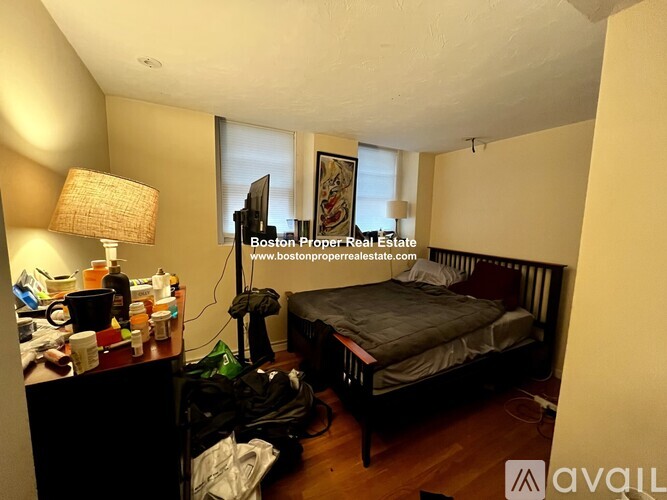 A bedroom with a bed, desk, and chair.