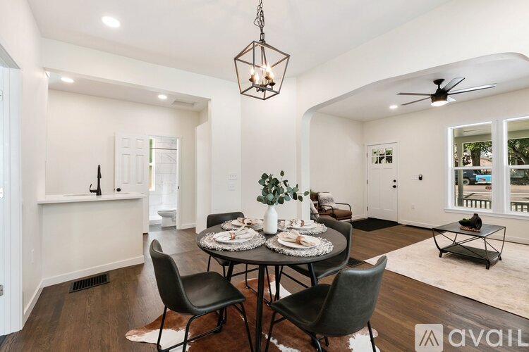 A dining room with a table set for four and a view of the backyard.