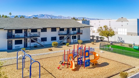 A playground with a slide, swings, and a climbing frame.