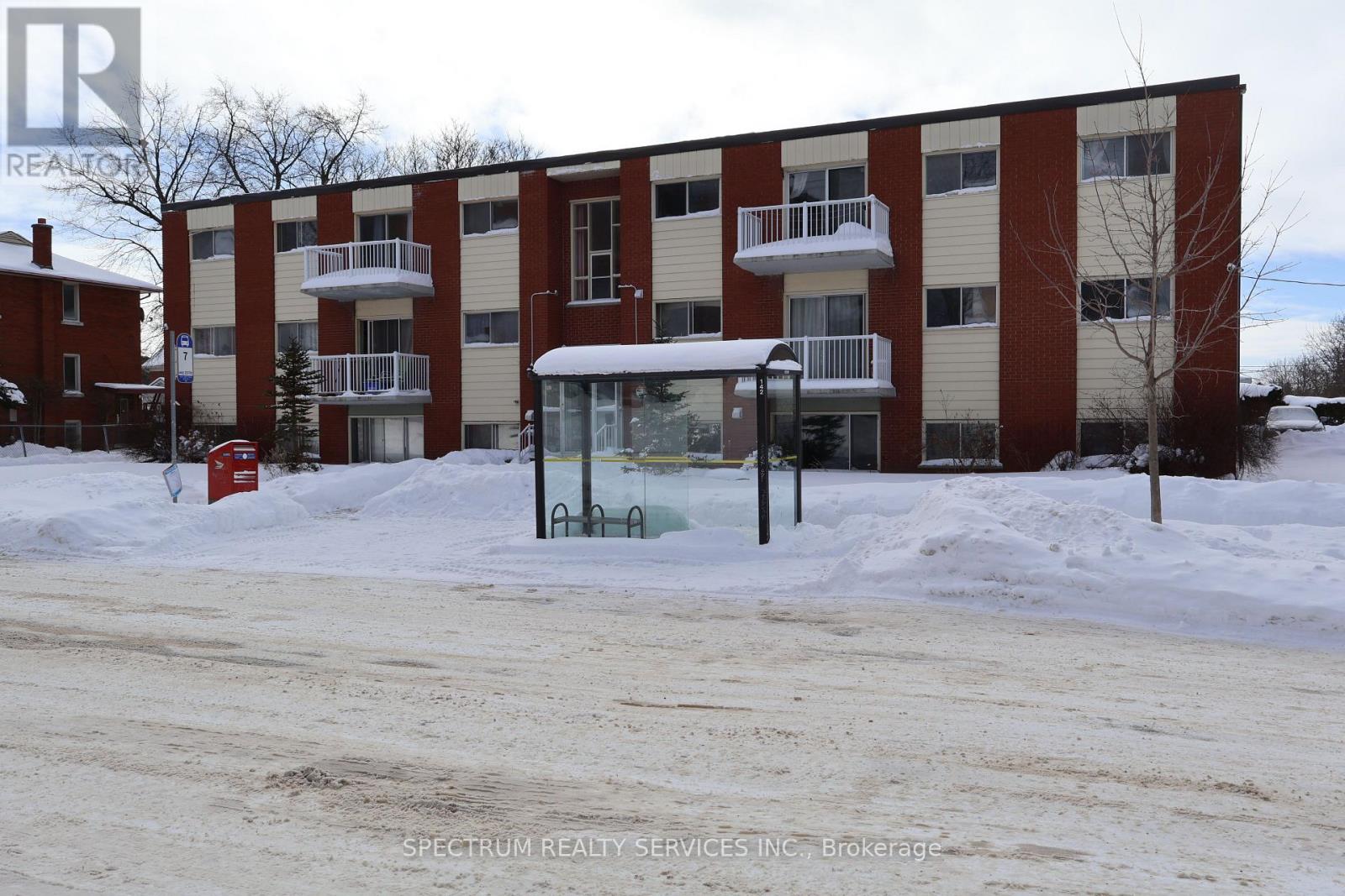 A snow-covered ground with a building in the background.