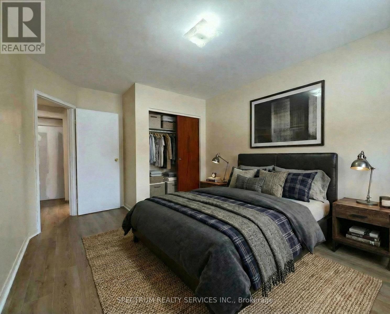 A bedroom with a bed, nightstand, and closet.