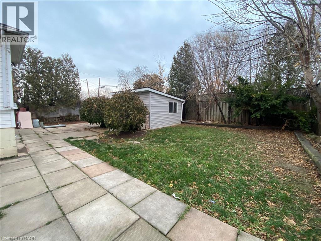 A backyard with a shed and a concrete walkway.