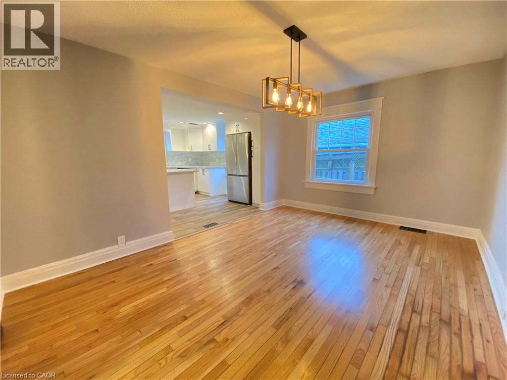 A room with wooden flooring and a chandelier hanging from the ceiling.